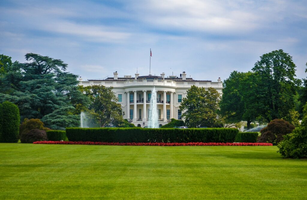 A fountain as a centrepiece of a large garden, with the White House standing in the background.