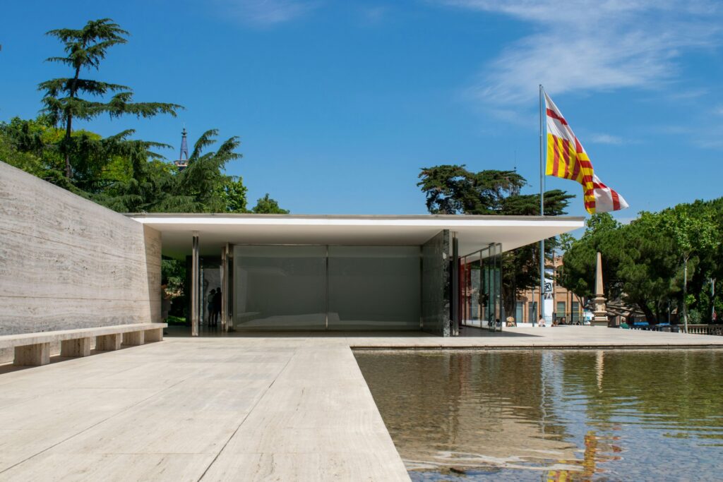 Barcelona Pavilion, Spain. A building with clean grey edges, overlooking a pool.