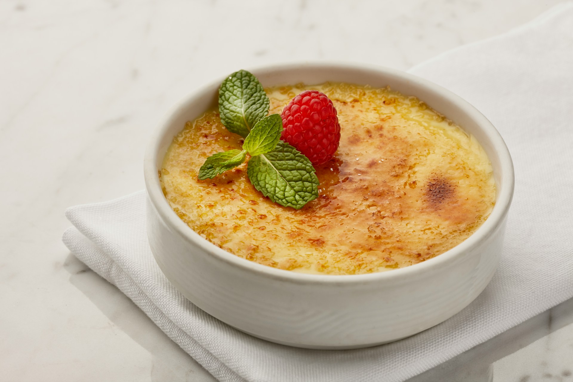 creme brulee pudding with a raspberry on top