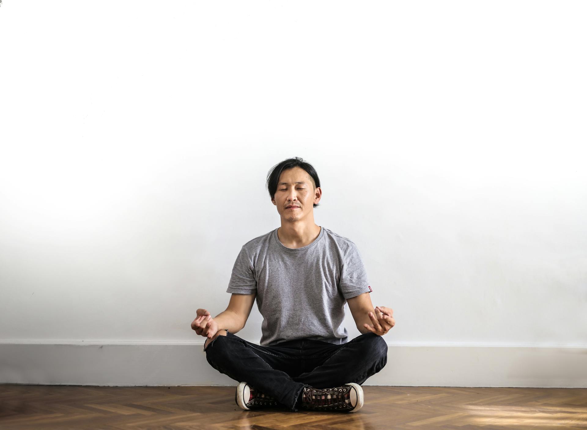 Man sitting on wooden floor meditating