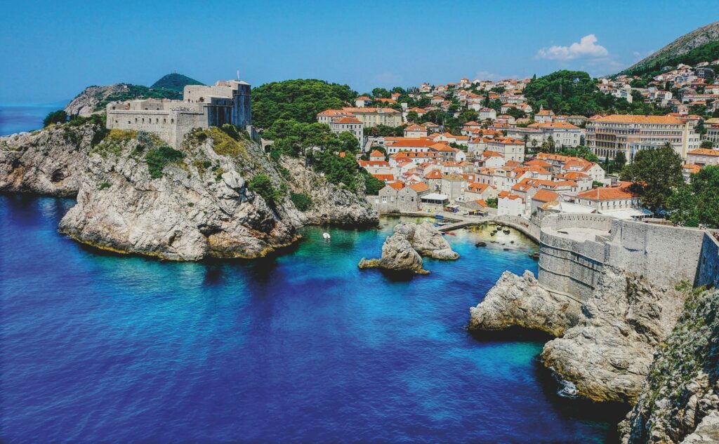 The harbour of Dubrovnik, with clear blue waters, white buildings and terracotta roofs